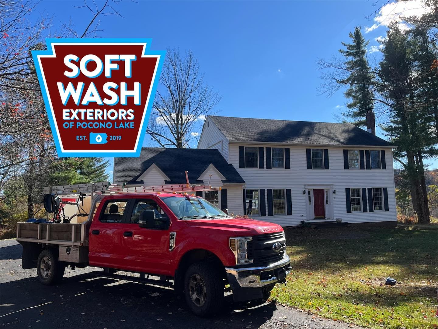 White colonial house, red truck, fall day
